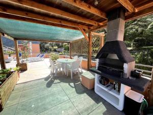 een patio met een fornuis, een tafel en stoelen bij La Terrazza - Solarium Privato 150mq Vista Lago in Riva del Garda