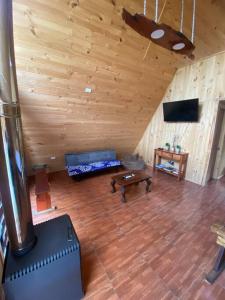 una sala de estar con sofá y mesa en una cabaña en Cabaña Ataraxia (RDS), en Riñinahue