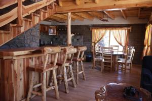 a kitchen with a bar and a dining room at Grand Mountain Cabañas Creel in Creel