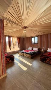 a large room with two beds and a ceiling at Wadi Rum Magic Camp in Wadi Rum