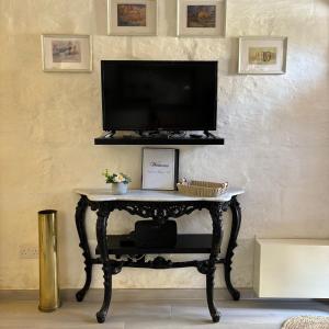 uma televisão numa mesa numa sala de estar em Townhouse 7 em Dingli