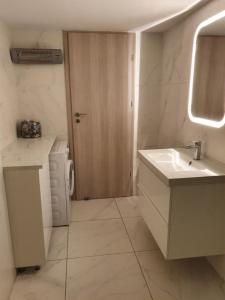 a bathroom with a sink and a washing machine at Elegance in Nicosia