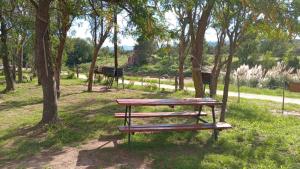 una mesa de picnic en un parque con árboles en La Alpina en Panaholma