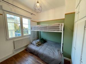 a bedroom with a bunk bed and a window at La maison Grand Cru in Arveyres