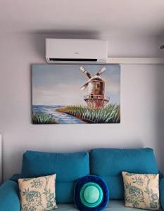 a painting hanging on a wall above a couch at Apartamento Perla Atalaya in Puerto del Carmen