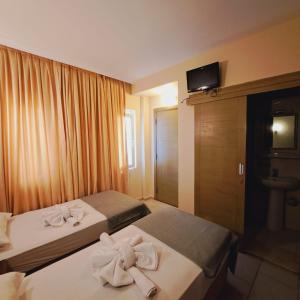 Dos camas en una habitación de hotel con toallas. en ANDOYA pansiyon, en Bodrum City