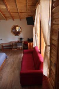 a living room with a red couch in a room at Grand Mountain Cabañas Creel in Creel