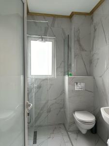 a bathroom with a shower and a toilet and a sink at Summer Gate Hotel in Ksamil