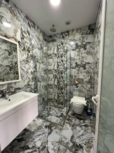 a bathroom with a shower and a sink and a toilet at Summer Gate Hotel in Ksamil