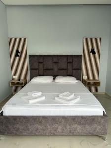 a bed with two white towels on top of it at Summer Gate Hotel in Ksamil