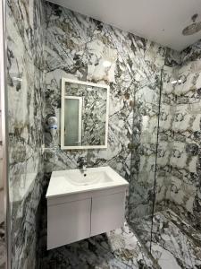 a bathroom with a sink and a mirror at Summer Gate Hotel in Ksamil