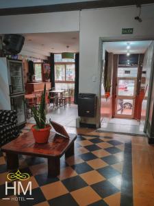 a living room with a table and a checkerboard floor at HOTEL HM in Córdoba