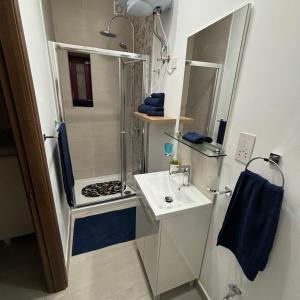 a small bathroom with a shower and a sink at Townhouse 7 in Dingli +23 photos