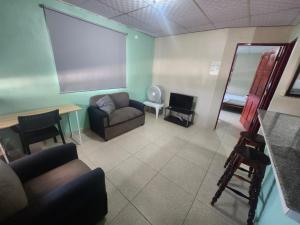 La Casa Buena Esperanza في بينونوم: غرفة معيشة بها أريكة وشاشة كبيرة