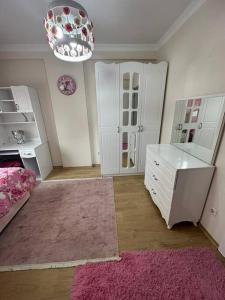 a bedroom with a pink rug and a white dresser at شقة باطلالة على البحر in Istanbul