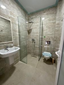 a bathroom with a shower and a sink and a toilet at Summer Gate Hotel in Ksamil