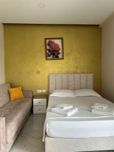 a bedroom with a bed and a couch at Summer Gate Hotel in Ksamil
