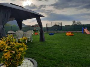 a park with a playground with a tent and chairs at The Bosna River in Vreoca