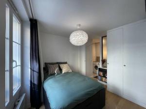 a bedroom with a bed and a large window at Double appartement - Le Marais in Paris