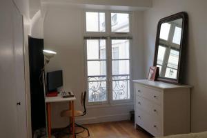 a bedroom with a mirror and a dresser with a mirror at Double appartement - Le Marais in Paris