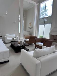 a living room with white furniture and windows at Enseada Premium Suítes in Guarujá