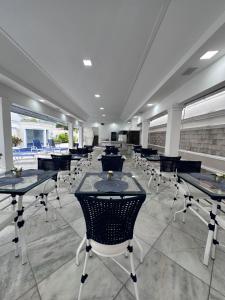 a dining room with tables and chairs and windows at Enseada Premium Suítes in Guarujá