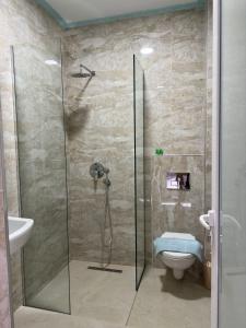a bathroom with a shower and a toilet at Summer Gate Hotel in Ksamil