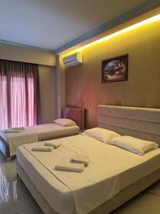 a hotel room with two beds and a window at Summer Gate Hotel in Ksamil