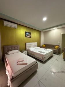 a bedroom with two beds and a couch at Summer Gate Hotel in Ksamil