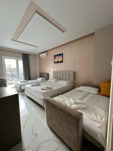 a room with three beds and a window at Summer Gate Hotel in Ksamil