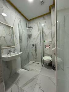 a bathroom with a shower and a sink and a toilet at Summer Gate Hotel in Ksamil