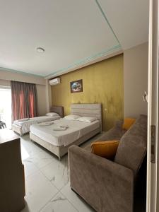 a hotel room with two beds and a couch at Summer Gate Hotel in Ksamil