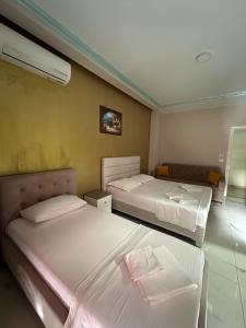 a bedroom with two beds and a room with at Summer Gate Hotel in Ksamil