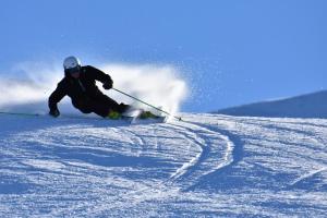 チェザーナ・トリネーゼにあるRifugio Baita Gimontの雪に覆われた坂道をスキーしている男
