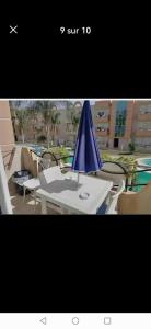 a table with a blue umbrella on top of it at Résidence dunes du golf kantaoui in Sousse