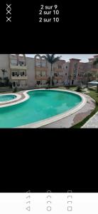 a picture of a swimming pool in front of a building at Résidence dunes du golf kantaoui in Sousse