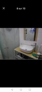 uma casa de banho com um lavatório branco e um espelho. em Résidence dunes du golf kantaoui em Sousse
