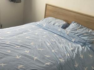 a bed with a blue comforter with stars on it at Stopin in Crawley