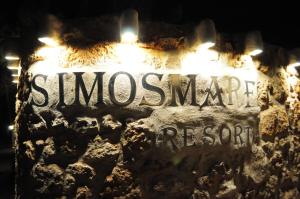 a sign for a restaurant on a wall at night at Simosmare Resort in Elafonisos