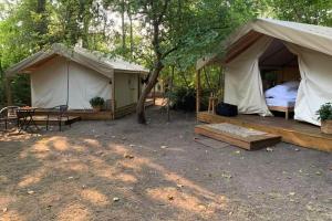 a couple of tents with a bed and a table at The Fox Den in Delta
