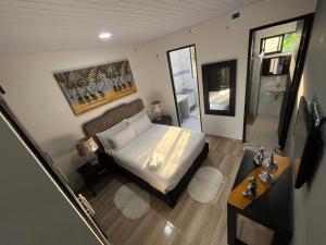 um pequeno quarto com uma cama e um espelho em Rio Aparta-Hotel 4 em Letícia