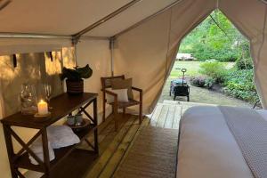 a tent with a bed and a table with a candle at The Fox Den in Delta