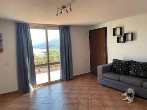 a living room with a couch and a large window at Appartamento Blue IUN T1261 in Cala Gonone +39 photos