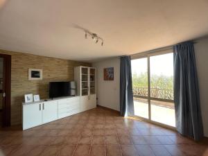 a living room with a tv and a large window at Appartamento Blue in Cala Gonone +39 photos