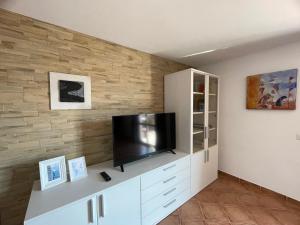 a living room with a television on a white cabinet at Appartamento Blue IUN T1261 in Cala Gonone