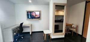 a room with a desk and a tv on a wall at Hotel BE Suites Cali in Cali