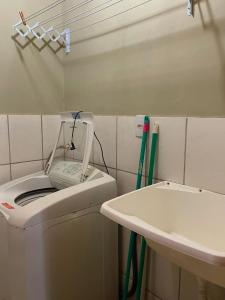 un baño con lavadora junto a un lavabo en Família Cavalli en Gramado