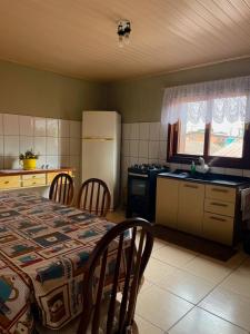 a kitchen with a table and chairs and a refrigerator at Família Cavalli in Gramado