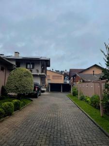 a brick driveway in a residential neighborhood with a house at Família Cavalli in Gramado