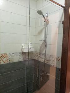 um chuveiro com uma porta de vidro na casa de banho em Monument Suites em Amã
